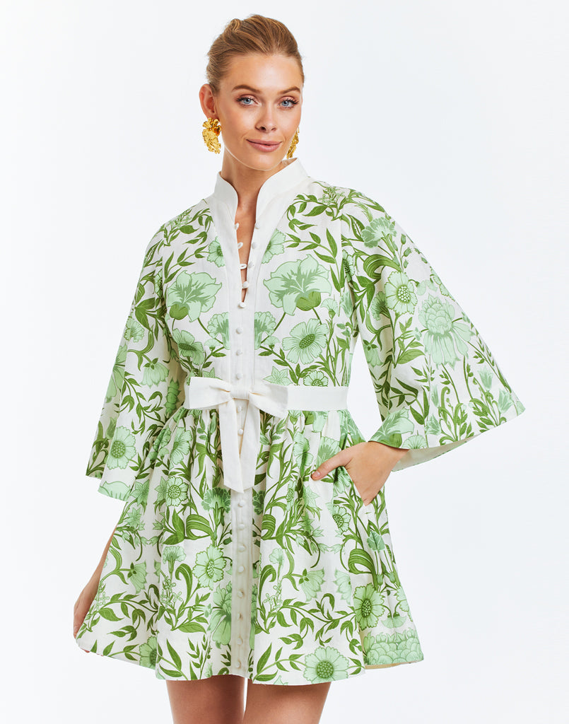 Green floral printed mini dress with butterfly sleeves and mandarin collar. Featuring side pockets and a front bow detail.