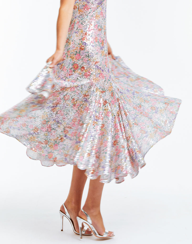 Printed sequined party dress with v-neck line, pleated skirt, and ribbon straps.