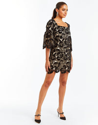 Black velvet floral lace mini dress with square neckline, bell sleeves and scalloped hemlines. 
