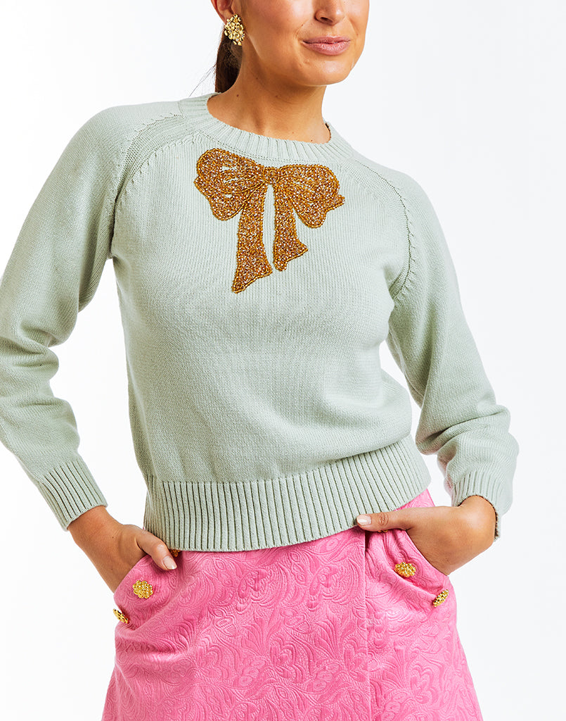 Tailored crew neck sweater with a front center  hand-beaded sparkly bow embellishment. 