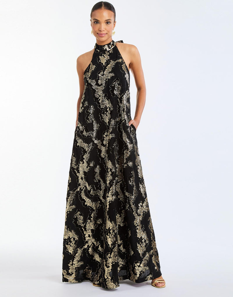 Adelina Gown in Black/Gold front – metallic jacquard evening gown with halter bow neckline, faux ruffle back, A-line silhouette, and side seam pockets by Mestiza New York.