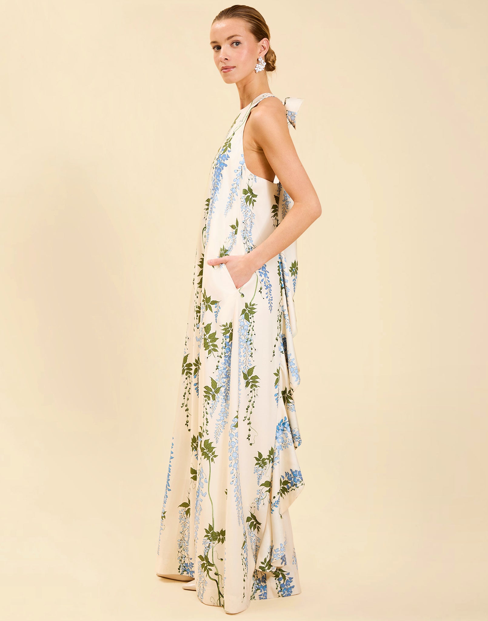 Adelina Gown in Wisteria Toile stretch crepe with halter neckline, cascading bow back detail, A-line silhouette, and hidden side pockets.