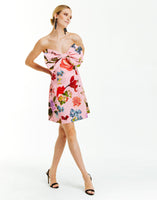 pink strapless mini dress with bold pink garden floral print and oversized front bow detail.