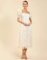 Alessandra Terno Midi Dress in Ivory broderie anglaise lace with sculptural terno sleeves, scalloped neckline, and elegant column midi silhouette.