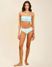 Model wearing Rita Convertible Bikini Bottoms in Grotto Stripe, reversible low-rise swim bottom with subtle cheeky back coverage.