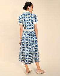 Woman wearing the Mestiza Billie Collared Shirt Dress in Solihiya Navy print, featuring a collared neckline, pleated midi skirt, contrast ivory button placket and cuffs, and lightweight twill fabrication.