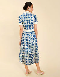 Woman wearing the Mestiza Billie Collared Shirt Dress in Solihiya Navy print, featuring a collared neckline, pleated midi skirt, contrast ivory button placket and cuffs, and lightweight twill fabrication.