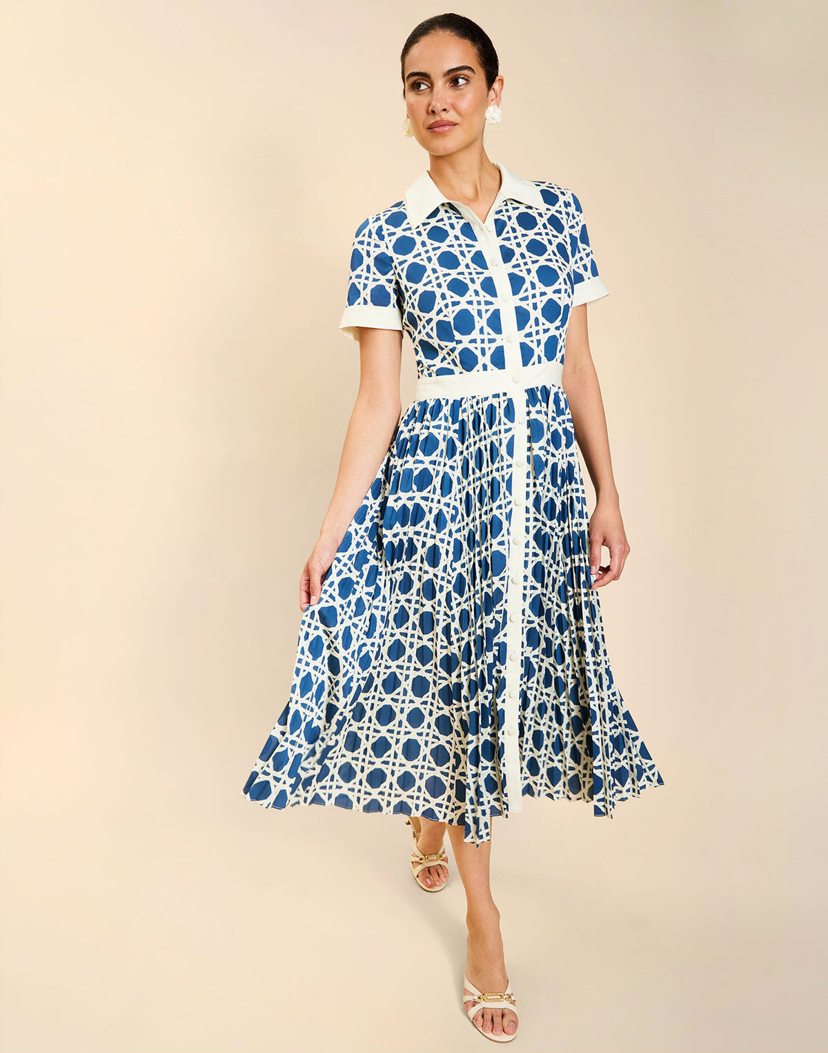 Woman wearing the Mestiza Billie Collared Shirt Dress in Solihiya Navy print, featuring a collared neckline, pleated midi skirt, contrast ivory button placket and cuffs, and lightweight twill fabrication.