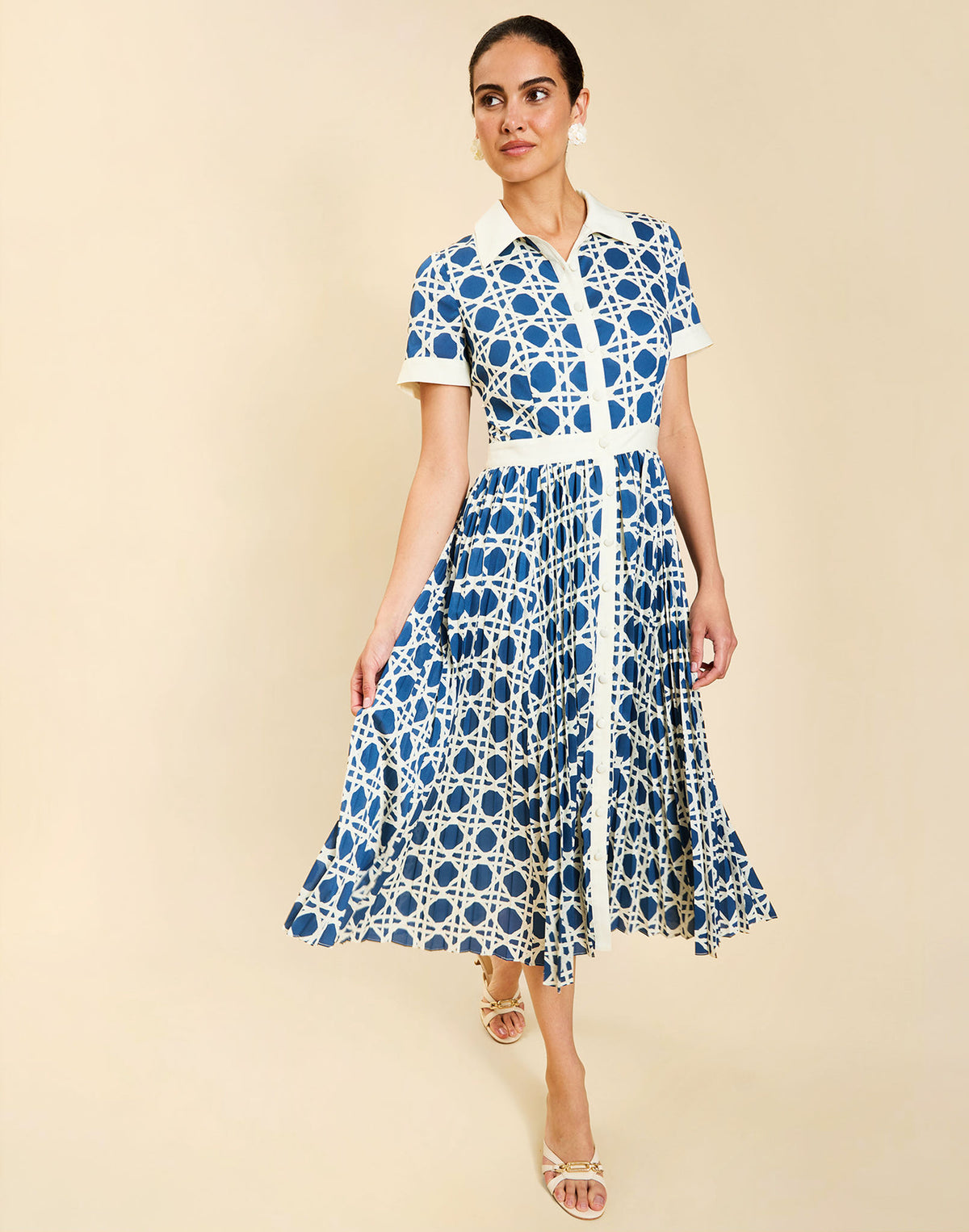 Woman wearing the Mestiza Billie Collared Shirt Dress in Solihiya Navy print, featuring a collared neckline, pleated midi skirt, contrast ivory button placket and cuffs, and lightweight twill fabrication.