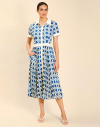 Woman wearing the Mestiza Billie Collared Shirt Dress in Solihiya Navy print, featuring a collared neckline, pleated midi skirt, contrast ivory button placket and cuffs, and lightweight twill fabrication.
