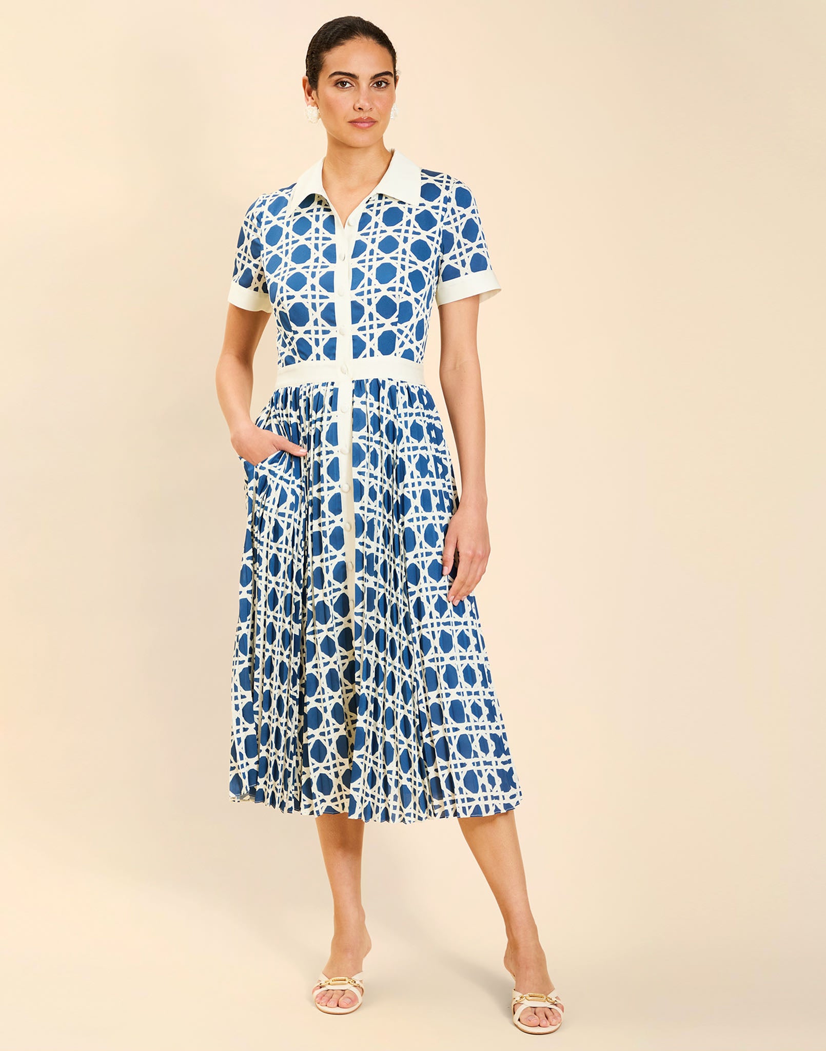 Woman wearing the Mestiza Billie Collared Shirt Dress in Solihiya Navy print, featuring a collared neckline, pleated midi skirt, contrast ivory button placket and cuffs, and lightweight twill fabrication.