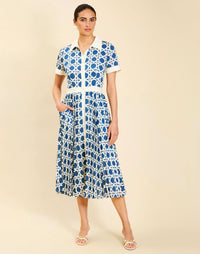 Woman wearing the Mestiza Billie Collared Shirt Dress in Solihiya Navy print, featuring a collared neckline, pleated midi skirt, contrast ivory button placket and cuffs, and lightweight twill fabrication.