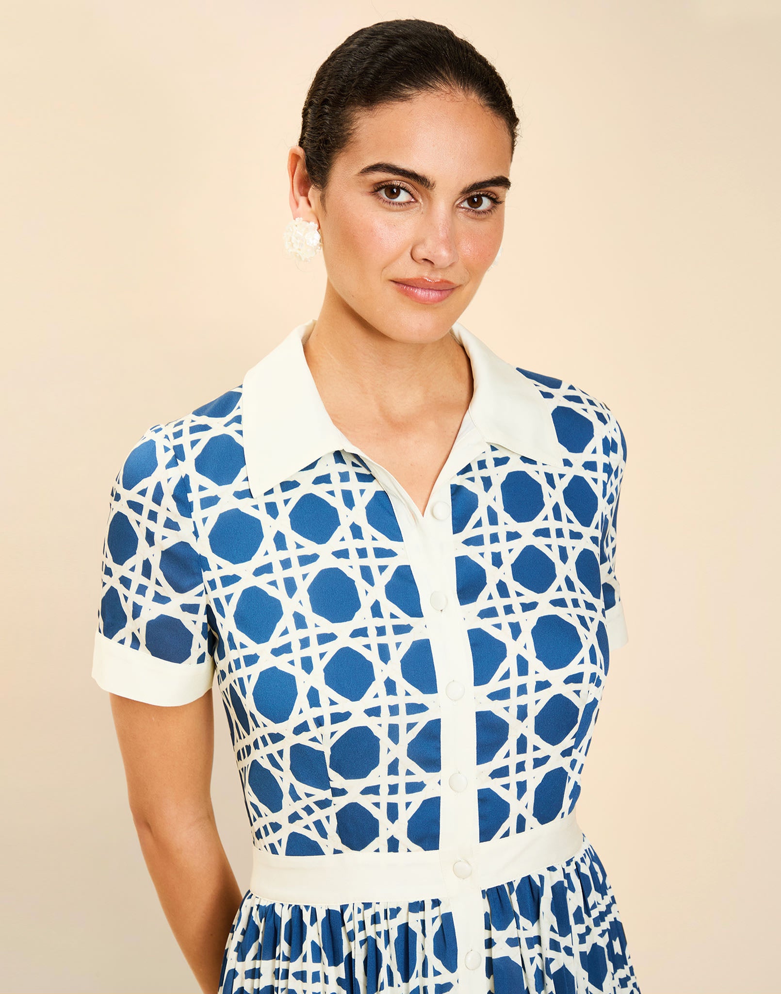 Woman wearing the Mestiza Billie Collared Shirt Dress in Solihiya Navy print, featuring a collared neckline, pleated midi skirt, contrast ivory button placket and cuffs, and lightweight twill fabrication.