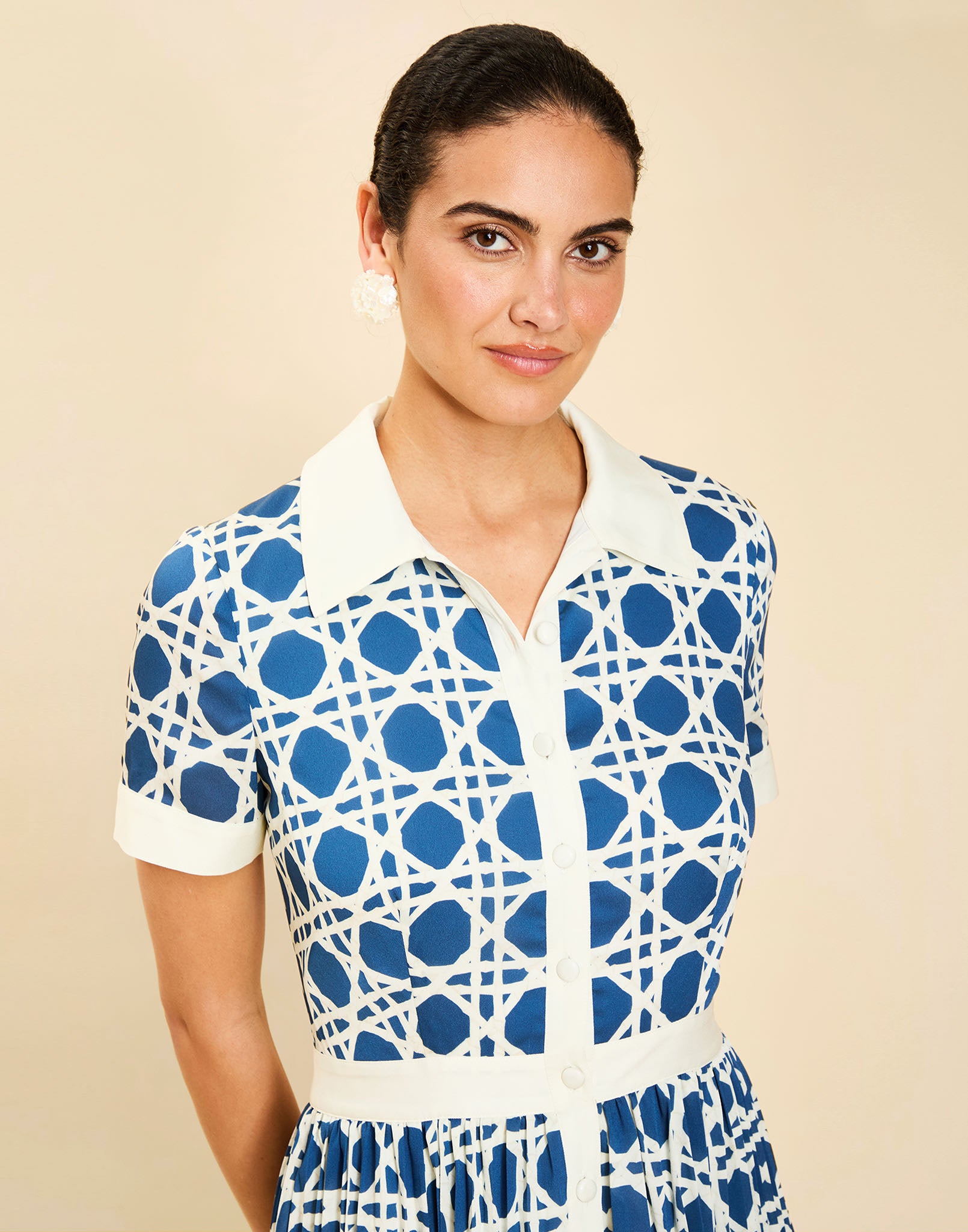 Woman wearing the Mestiza Billie Collared Shirt Dress in Solihiya Navy print, featuring a collared neckline, pleated midi skirt, contrast ivory button placket and cuffs, and lightweight twill fabrication.