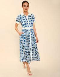 Woman wearing the Mestiza Billie Collared Shirt Dress in Solihiya Navy print, featuring a collared neckline, pleated midi skirt, contrast ivory button placket and cuffs, and lightweight twill fabrication.