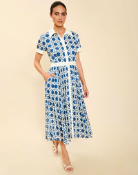 Woman wearing the Mestiza Billie Collared Shirt Dress in Solihiya Navy print, featuring a collared neckline, pleated midi skirt, contrast ivory button placket and cuffs, and lightweight twill fabrication.