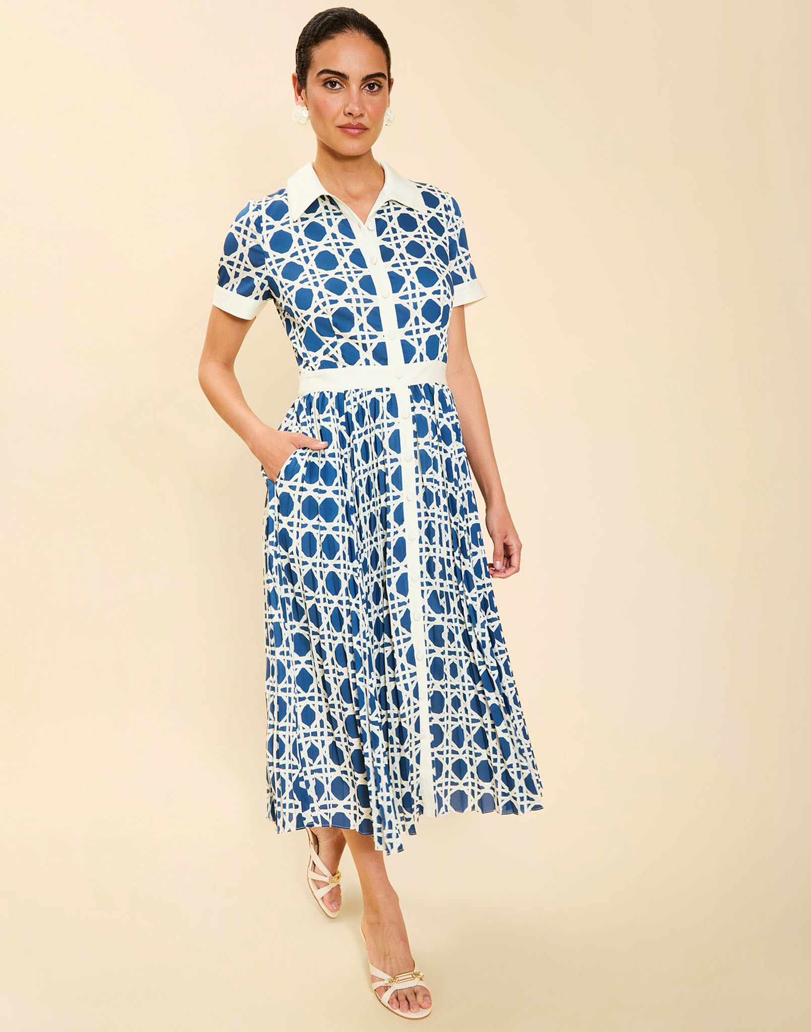 Woman wearing the Mestiza Billie Collared Shirt Dress in Solihiya Navy print, featuring a collared neckline, pleated midi skirt, contrast ivory button placket and cuffs, and lightweight twill fabrication.