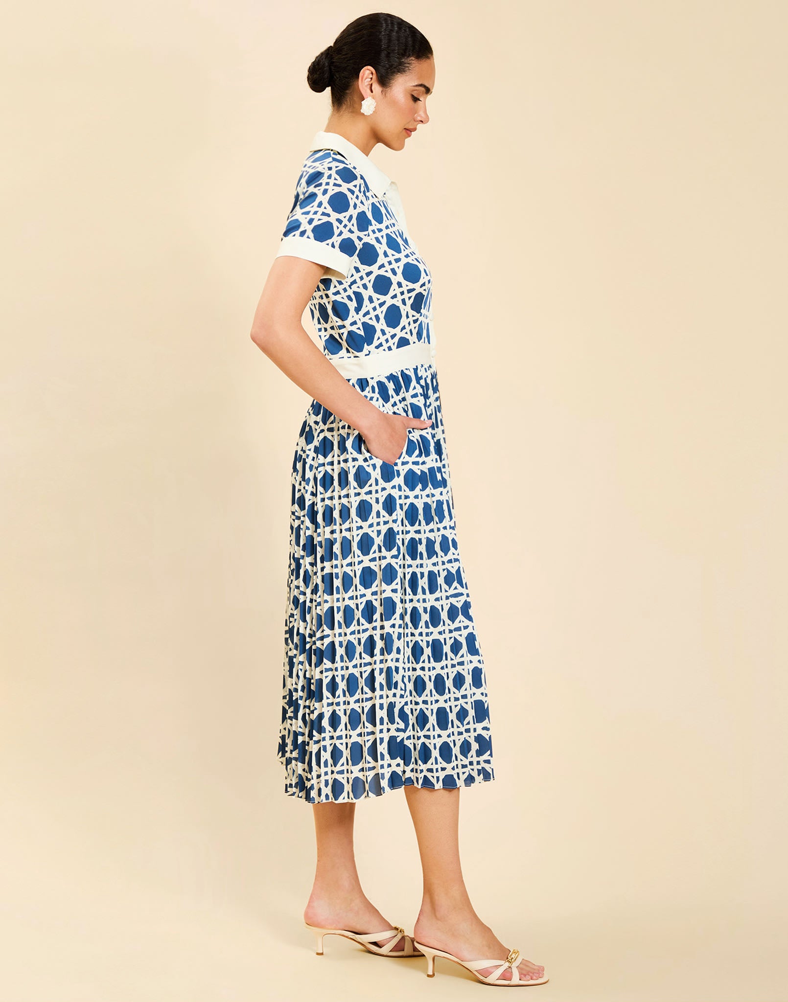 Woman wearing the Mestiza Billie Collared Shirt Dress in Solihiya Navy print, featuring a collared neckline, pleated midi skirt, contrast ivory button placket and cuffs, and lightweight twill fabrication.