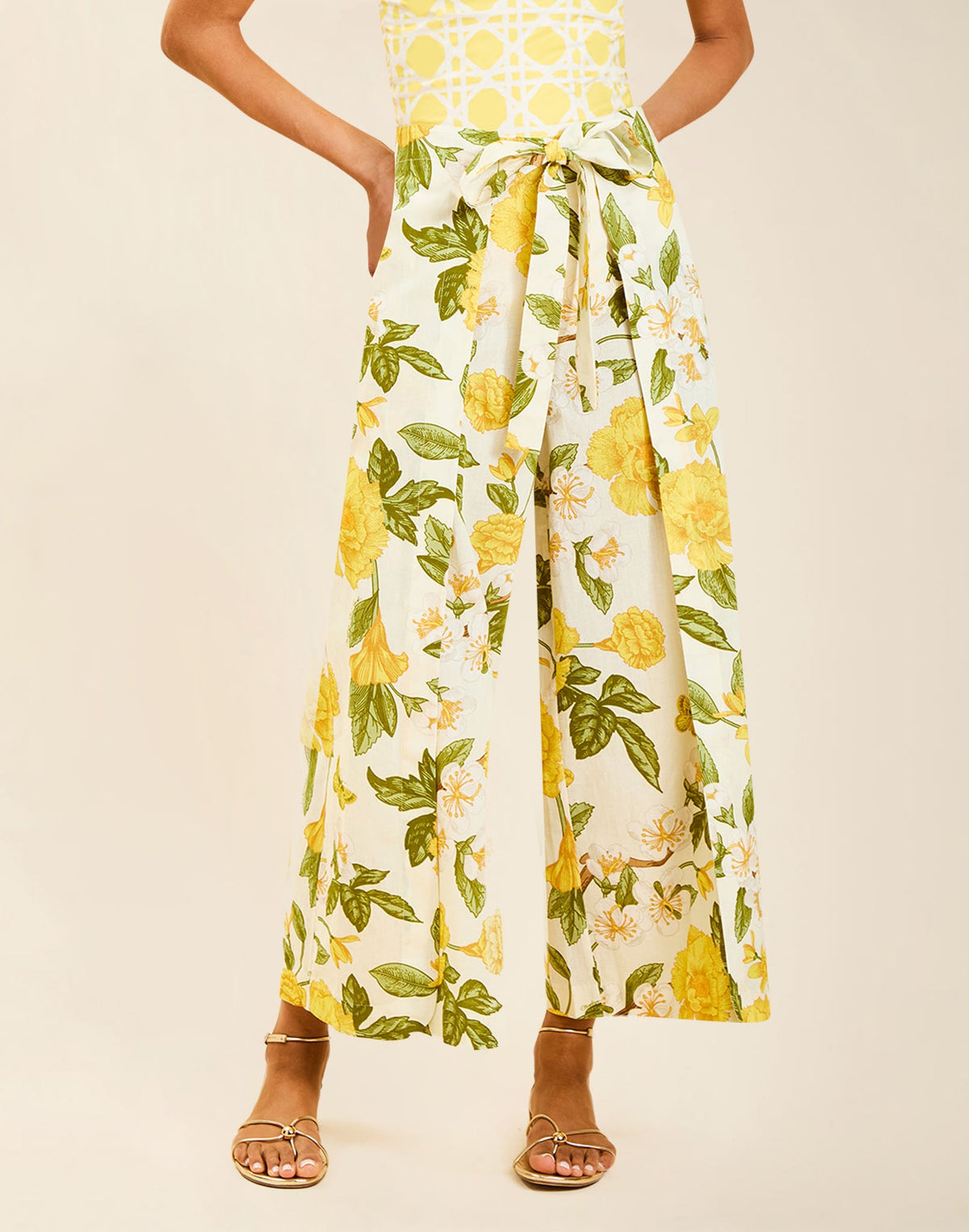 Model wearing Chloe Wrap Beach Pant in Golden Gardenia cotton-linen blend with wraparound panel and self-tie bow.