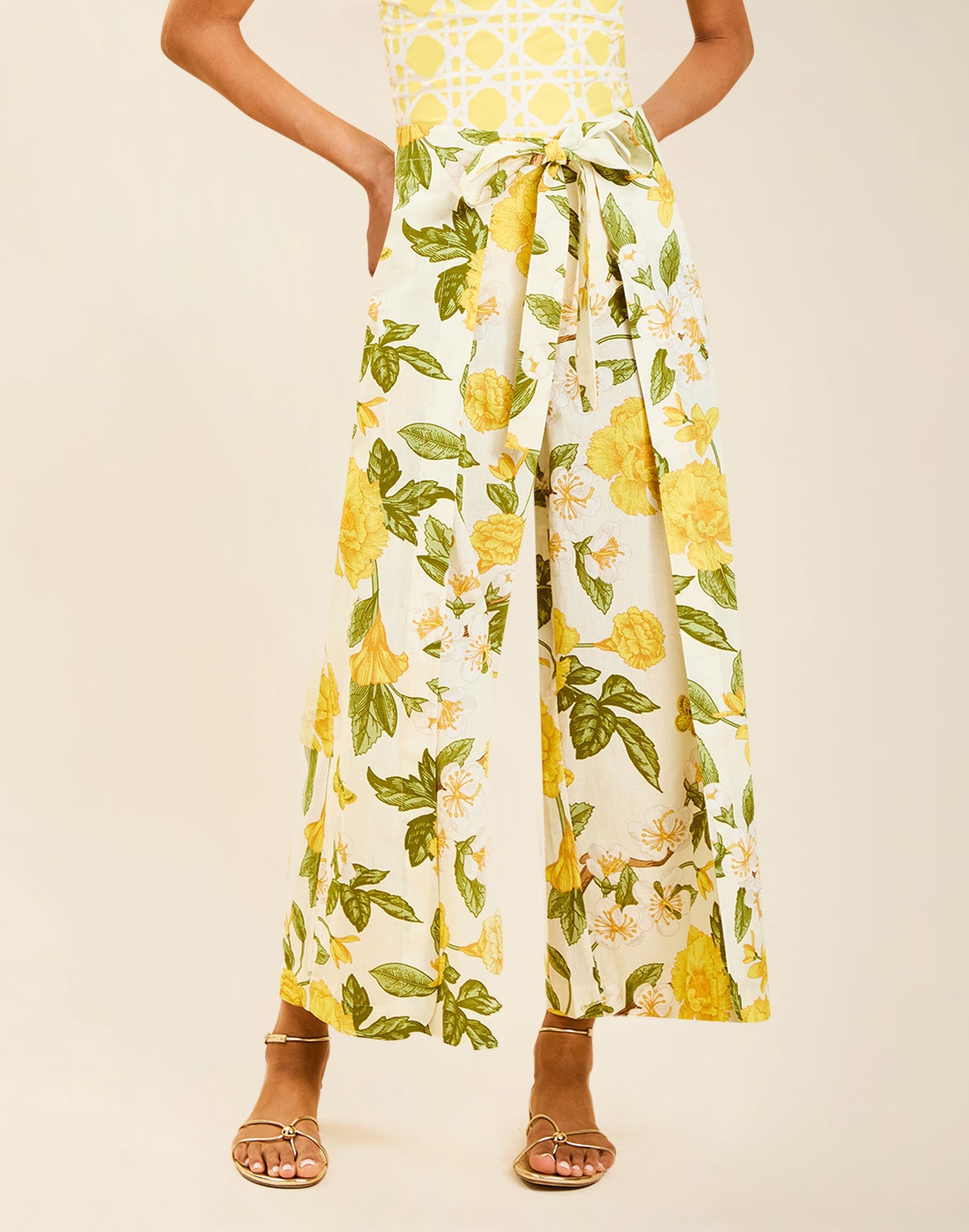 Model wearing Chloe Wrap Beach Pant in Golden Gardenia cotton-linen blend with wraparound panel and self-tie bow.