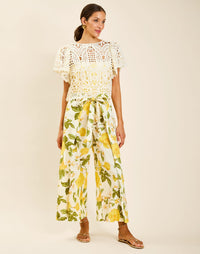 Model wearing Chloe Wrap Beach Pant in Golden Gardenia cotton-linen blend with wraparound panel and self-tie bow.