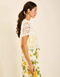 Model wearing Pasay Crochet Top in Ivory with boat neckline and butterfly sleeves in crochet lace.