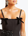 Black stretch crepe fitted midi dress with flared skirt. Velvet bow details on front below the straps. 