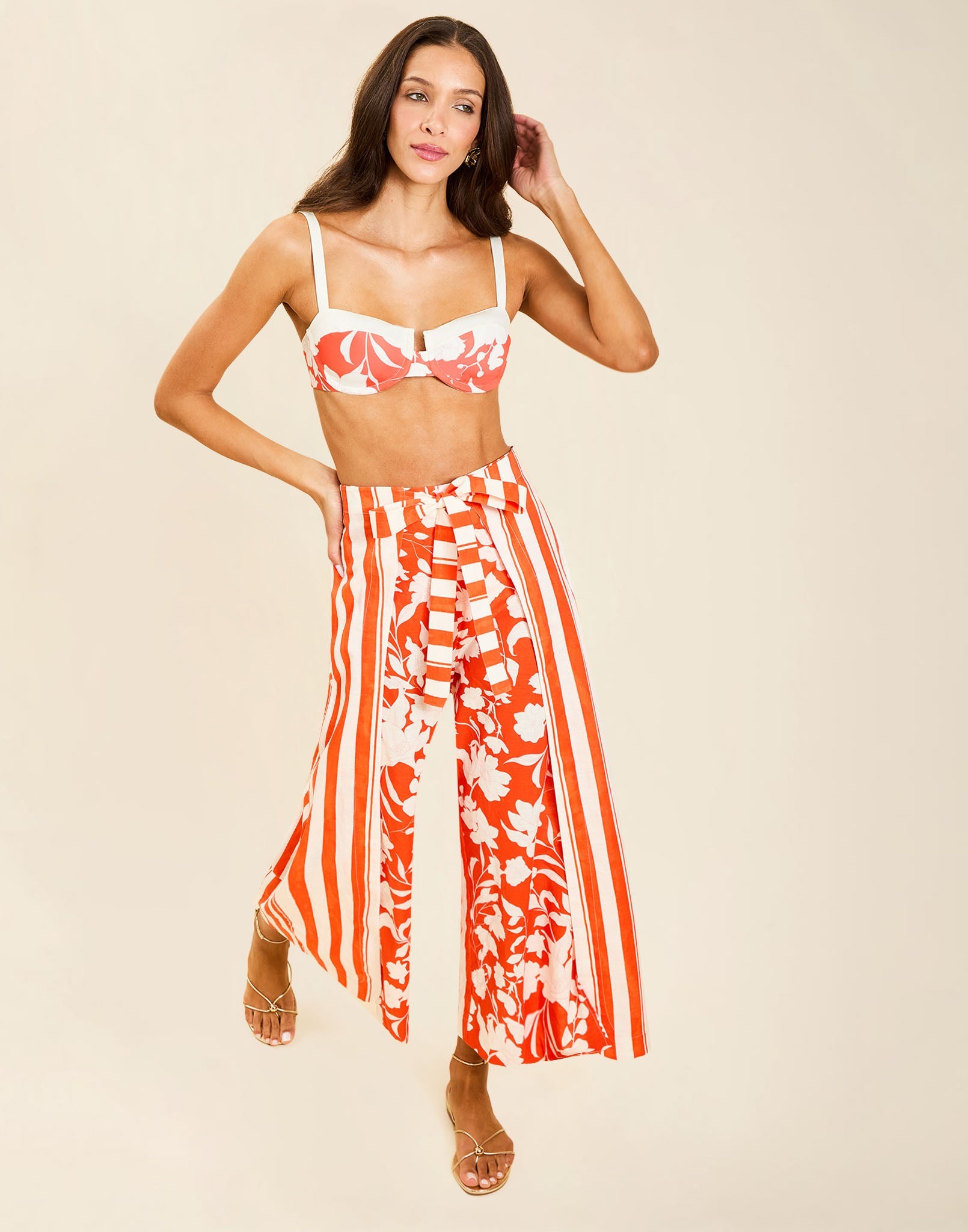 Model wearing Chloe Wrap Beach Pant in Mandarin Stripe cotton-linen blend with wraparound panel and self-tie bow.