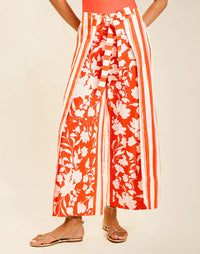 Model wearing Chloe Wrap Beach Pant in Mandarin Stripe cotton-linen blend with wraparound panel and self-tie bow.