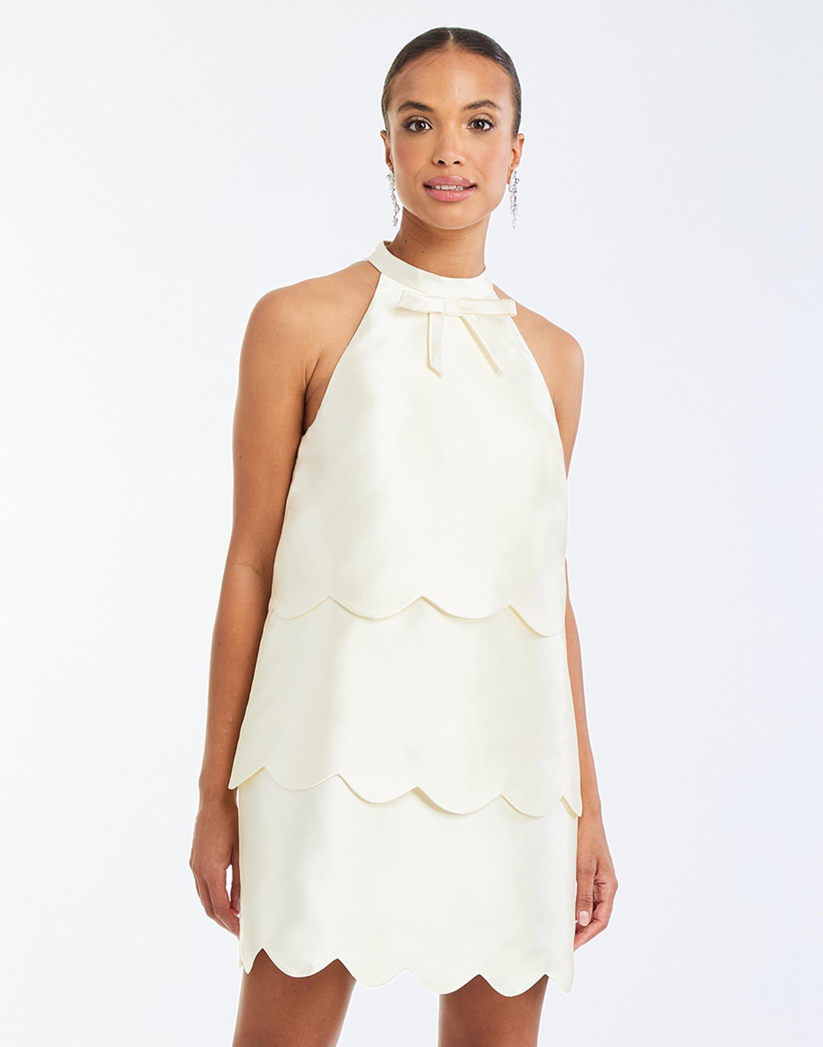 Cannes Convertible™ Mini Dress in Ivory front – cocktail mini dress with scalloped tiers, halter bow neckline, and convertible cropped top styling by Mestiza New York.