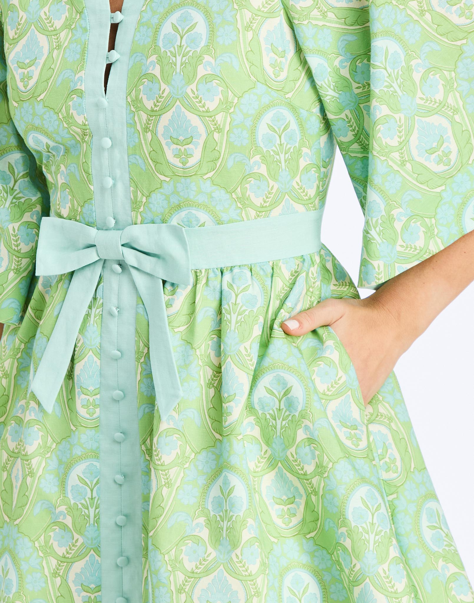 Detail - Carmen Mini Dress in Trellis Verte is a printed linen mini with mandarin collar, butterfly sleeves, and waist bow.