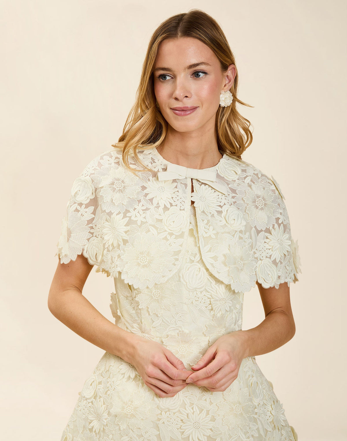 Carolina Lace Capelet in Ivory guipure lace with bow neckline detail, fitted shoulders, and elegant layering capelet silhouette.