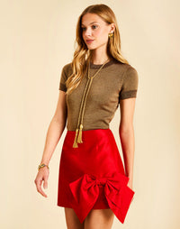 Carter Bow Mini Skirt in Red with a fitted waist and bow detail at the front left.
