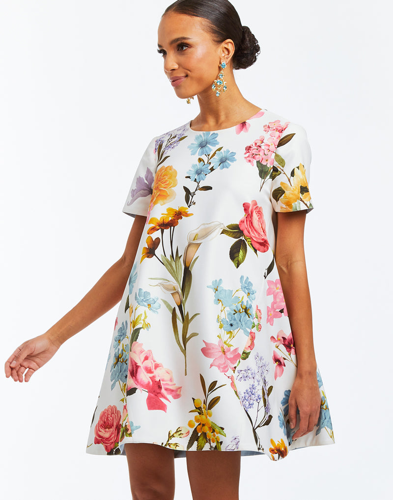 A-line, reversible mini dress with crew neckline and self-tie bow closure. Featuring bold floral print on one side and ocean blue on the reverse side. 