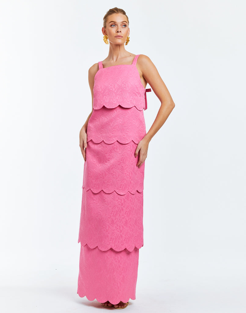Pink dress with 4 convertible capabilities: gown, midi, min and top. Scalloped tiers and micro bow details at rear base of shoulder straps.