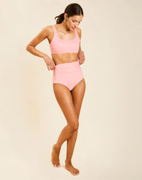Model wearing Orvieto Convertible Bikini Bottom in Florentine Blush with foldover high-waist and reversible solid option.
