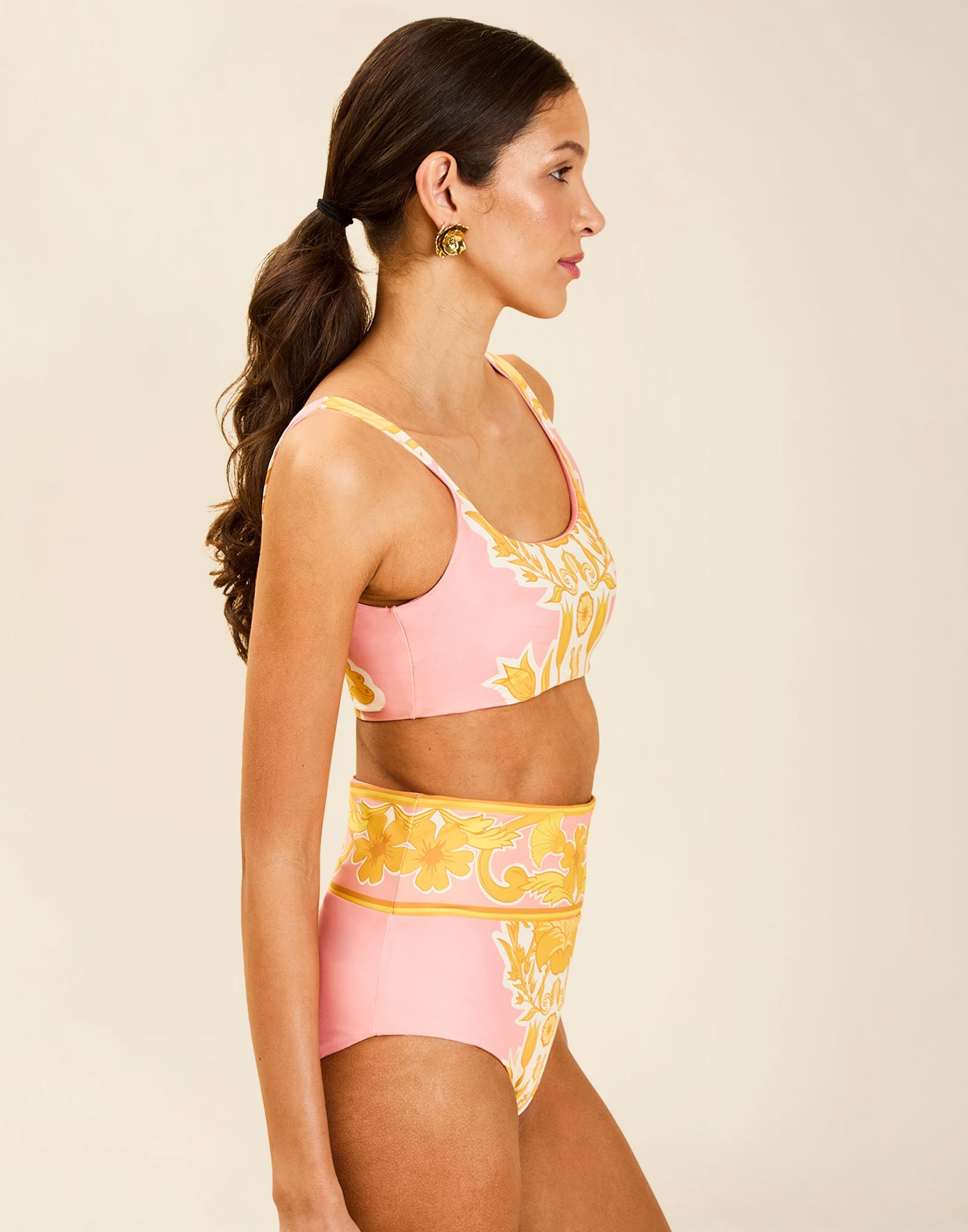 Model wearing Orvieto Convertible Bikini Bottom in Florentine Blush with foldover high-waist and reversible solid option.