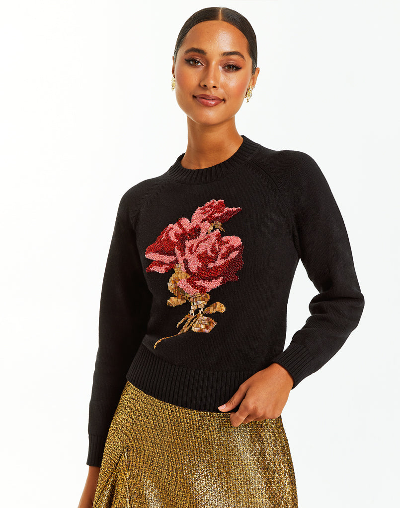 Black crew neck sweater with large beaded rose embellishment.