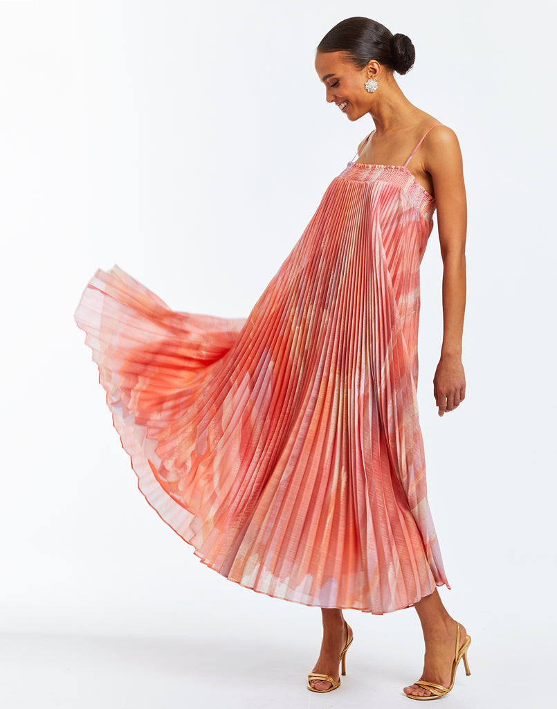 Convertible evening gown that can be styled in four different ways. Featuring a top with an oversized 3D floral embellishment on the bodice, and pleated skirt that can be worn at waist or at the bustline. Crafted from printed linen organza in sherbert ombre color.