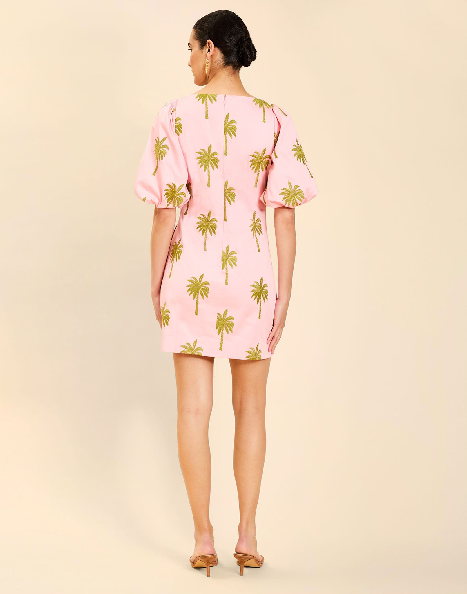 Woman wearing the Mestiza Donovan Mini Dress in English Rose, featuring a boat neckline, embroidered cotton poplin fabrication, fitted waist, balloon sleeves, subtle A-line skirt, and side seam pockets.