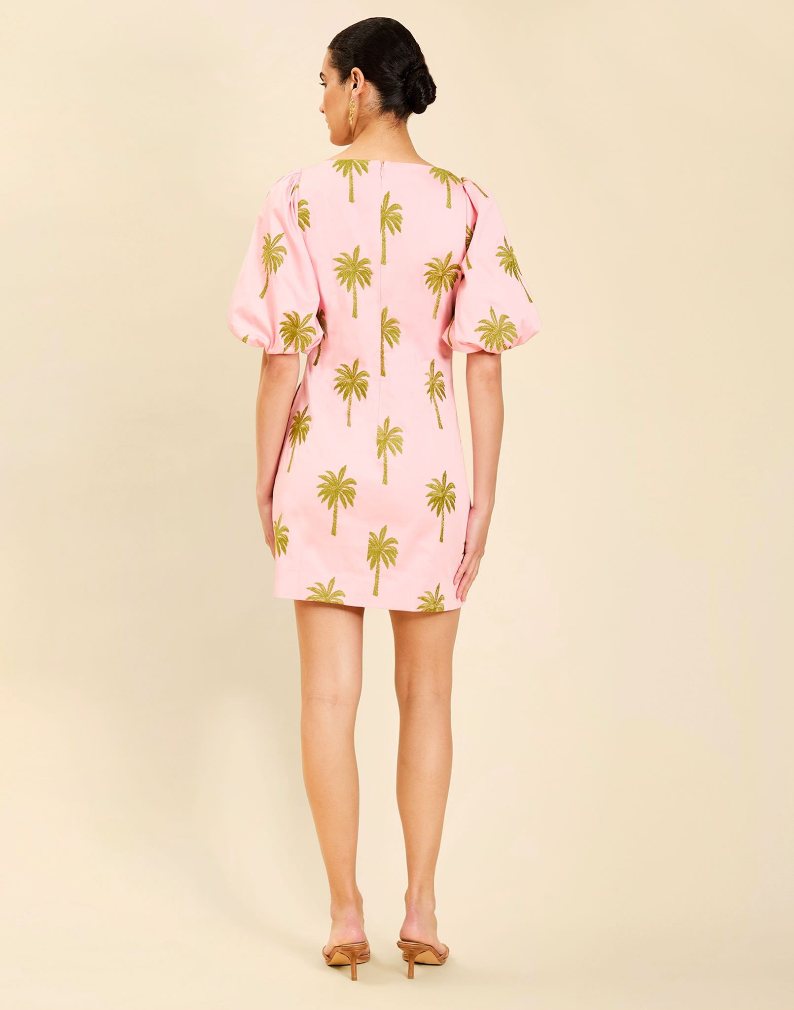 Woman wearing the Mestiza Donovan Mini Dress in English Rose, featuring a boat neckline, embroidered cotton poplin fabrication, fitted waist, balloon sleeves, subtle A-line skirt, and side seam pockets.