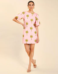 Woman wearing the Mestiza Donovan Mini Dress in English Rose, featuring a boat neckline, embroidered cotton poplin fabrication, fitted waist, balloon sleeves, subtle A-line skirt, and side seam pockets.