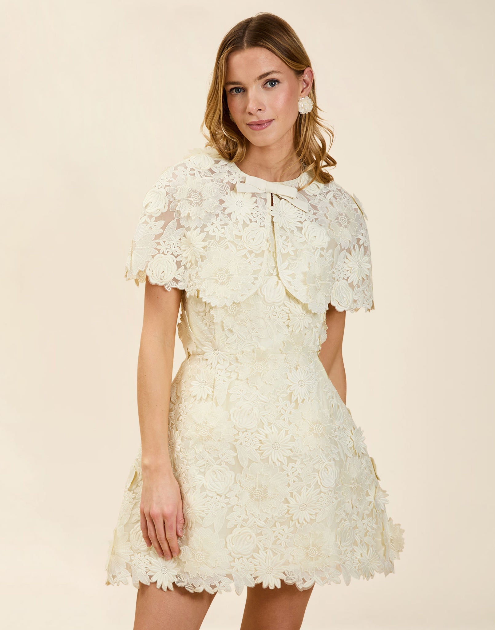 Carolina Lace Capelet in Ivory guipure lace with bow neckline detail, fitted shoulders, and elegant layering capelet silhouette.