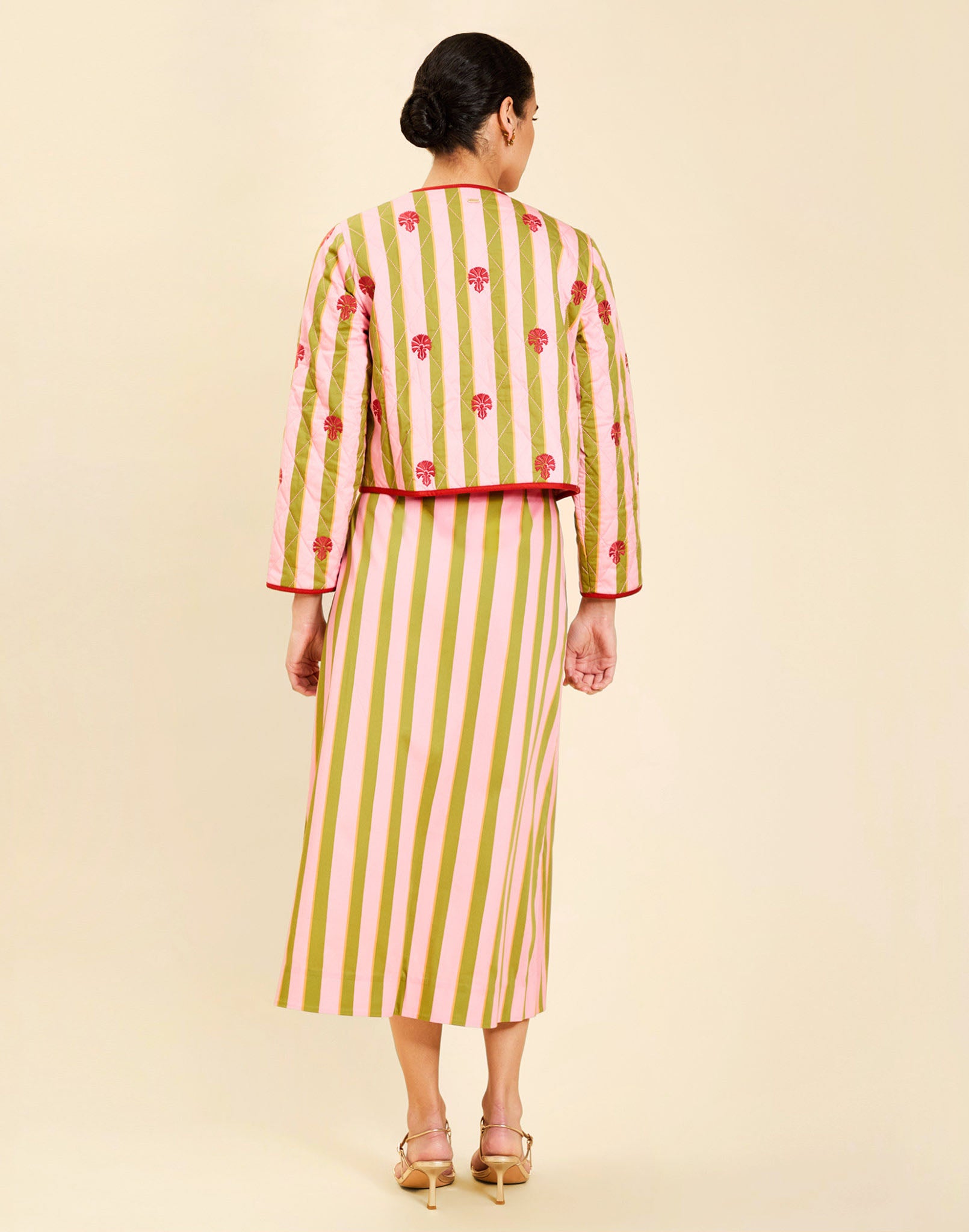 Woman wearing the Mestiza Este Convertible Jacket in Rose Provence print, featuring reversible construction, embroidered detailing, tilted diamond quilting, contrast piping, and full-length sleeves in cotton.