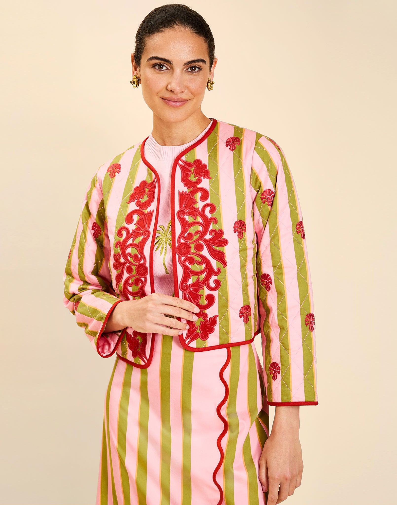 Woman wearing the Mestiza Este Convertible Jacket in Rose Provence print, featuring reversible construction, embroidered detailing, tilted diamond quilting, contrast piping, and full-length sleeves in cotton.