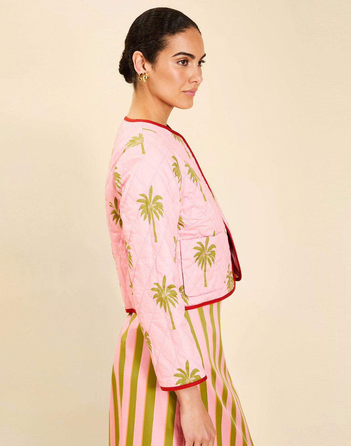 Woman wearing the Mestiza Este Convertible Jacket in Rose Provence print, featuring reversible construction, embroidered detailing, tilted diamond quilting, contrast piping, and full-length sleeves in cotton.