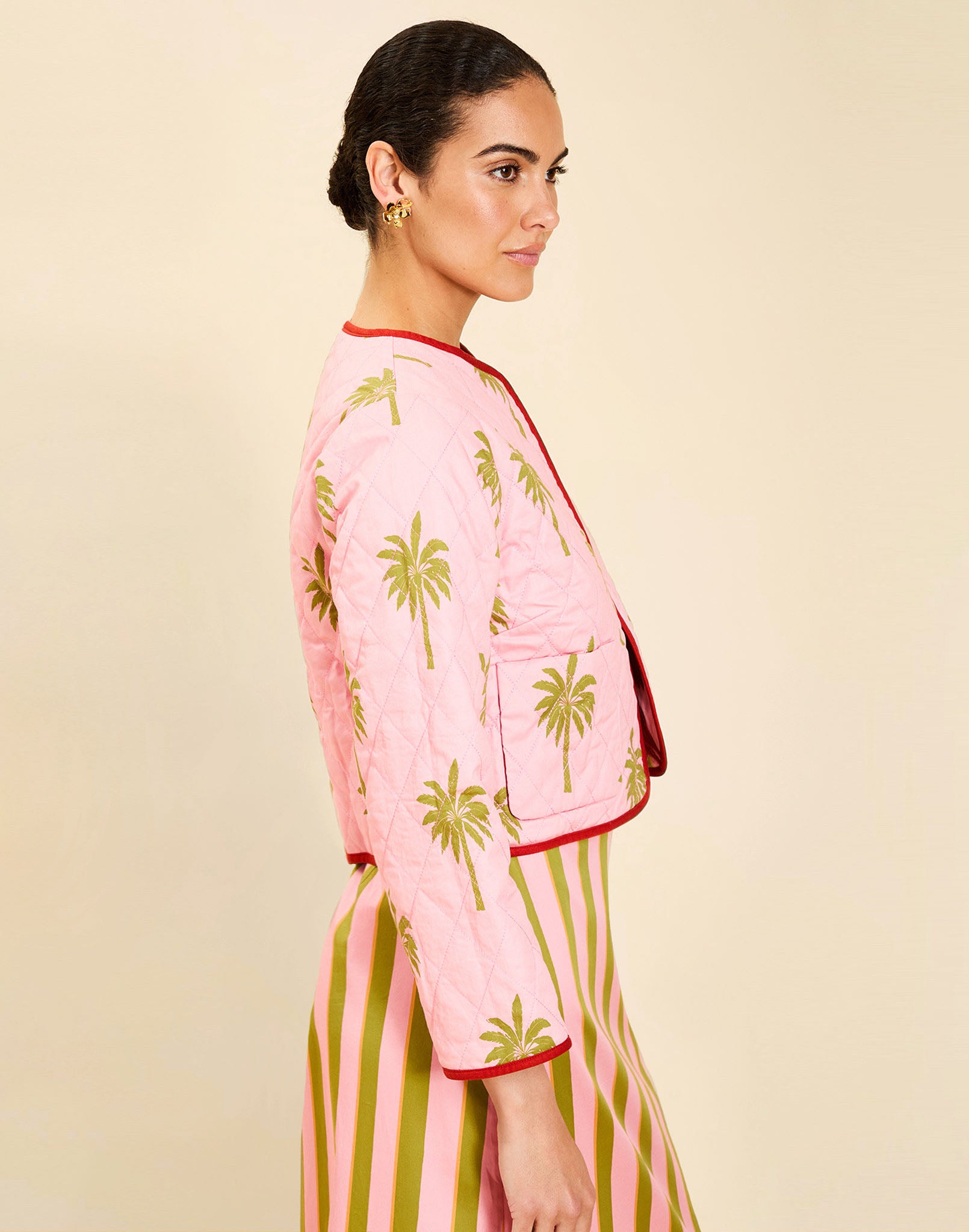 Woman wearing the Mestiza Este Convertible Jacket in Rose Provence print, featuring reversible construction, embroidered detailing, tilted diamond quilting, contrast piping, and full-length sleeves in cotton.