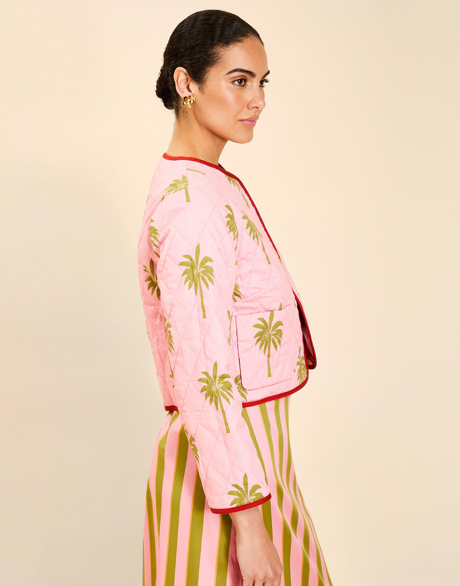 Woman wearing the Mestiza Este Convertible Jacket in Rose Provence print, featuring reversible construction, embroidered detailing, tilted diamond quilting, contrast piping, and full-length sleeves in cotton.