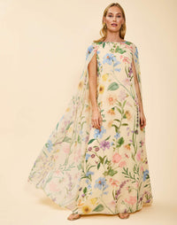Estrella Cape Gown in Blooming Vine chiffon with attached cape, boat neckline, flowing column silhouette, and side seam pockets.