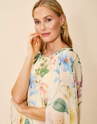 Estrella Cape Gown in Blooming Vine chiffon with attached cape, boat neckline, flowing column silhouette, and side seam pockets.